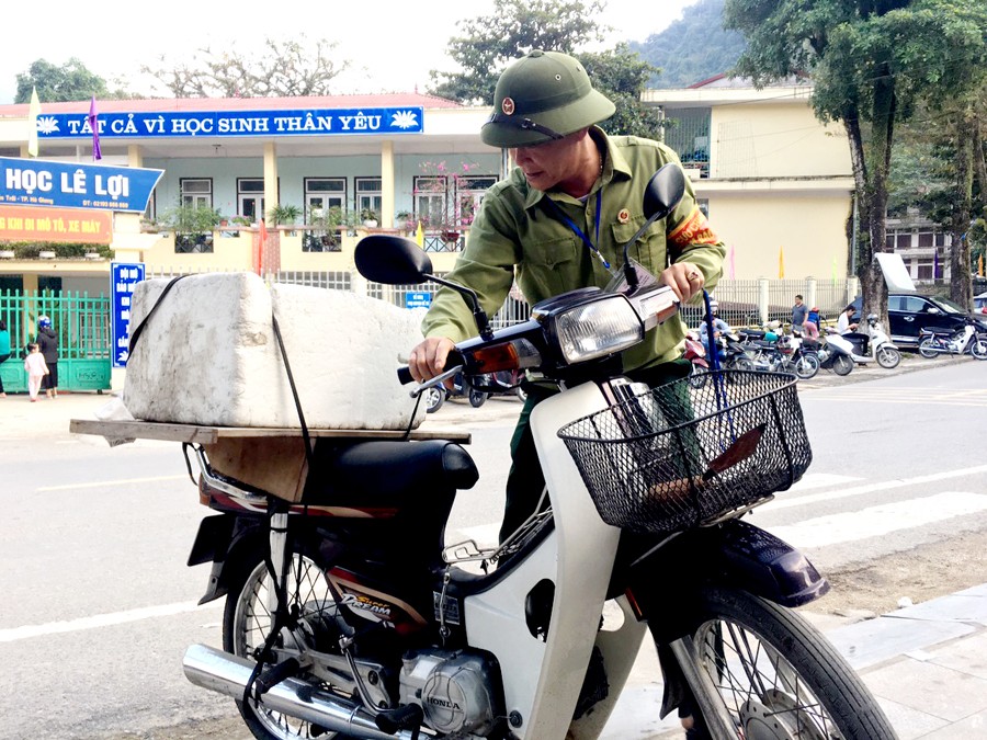 Cựu chiến binh dắt xe và hướng dẫn phụ huynh đỗ xe đúng nơi quy định