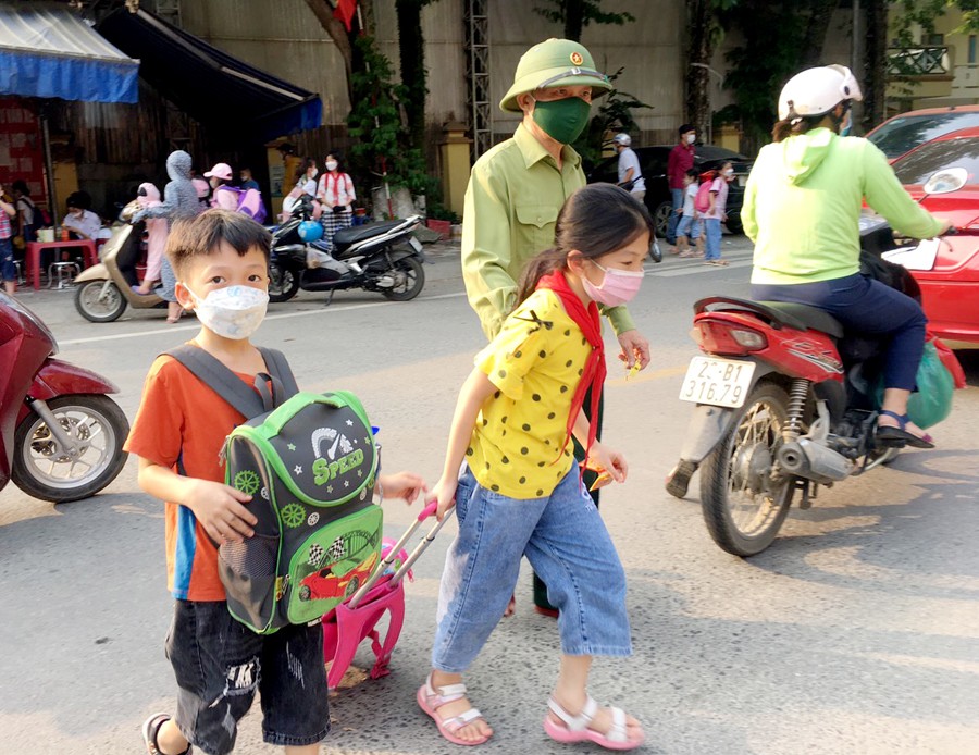 Cựu chiến binh dắt tay học sinh qua đường an toàn giờ tan học