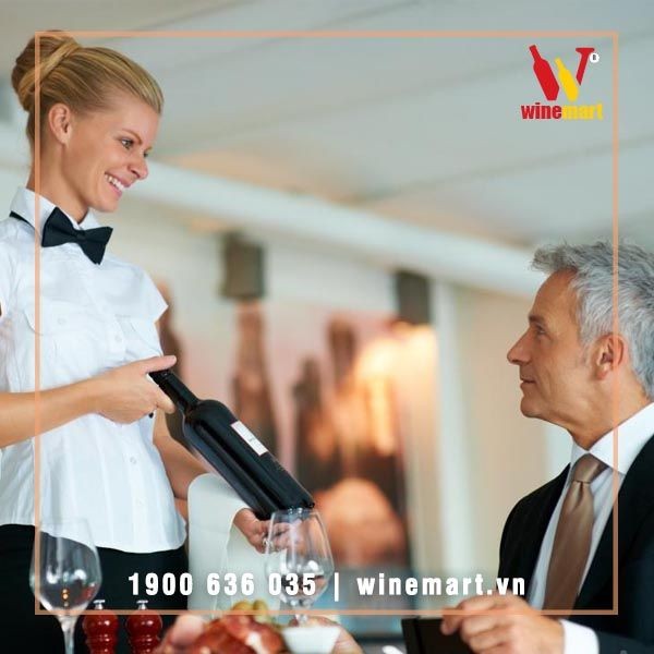 Nhân viên phục vụ xoay nhãn chai về phía khách hàng khi tư vấn