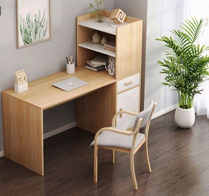 Bàn làm việc gọn gàng, có cây xanh nhỏ, hướng ra cửa sổ tràn ngập ánh sáng